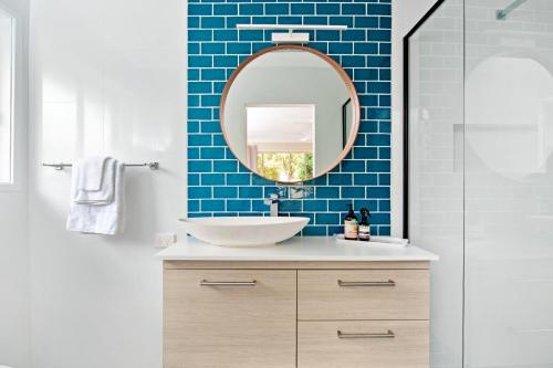a bathroom with a sink and a mirror at Southern Belle Mollymook in Mollymook