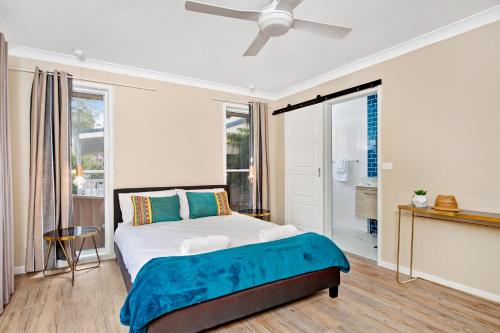 - une chambre avec un lit et un ventilateur de plafond dans l'établissement Southern Belle Mollymook, à Mollymook