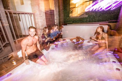 a group of people sitting in a hot tub at Ember Hostel in Denver