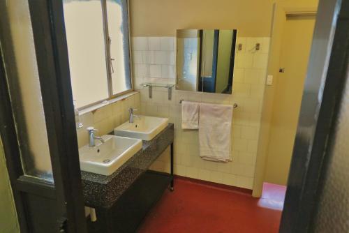 a bathroom with two sinks and a mirror at Pretoria Hotel in Mannum