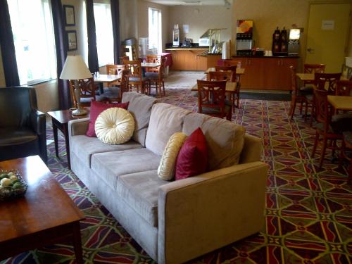 a living room with a couch and tables and chairs at Hawthorn Suites by Wyndham Rancho Cordova/Folsom in Rancho Cordova