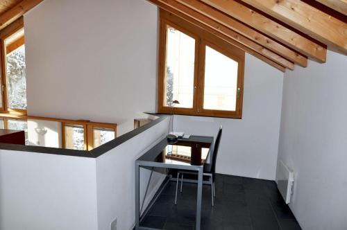 a small dining room with a table and windows at sur il muglin in Sent