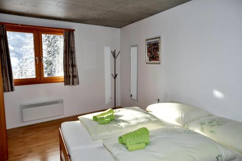 ein Schlafzimmer mit einem Bett mit grünen Kissen darauf in der Unterkunft sur il muglin in Sent
