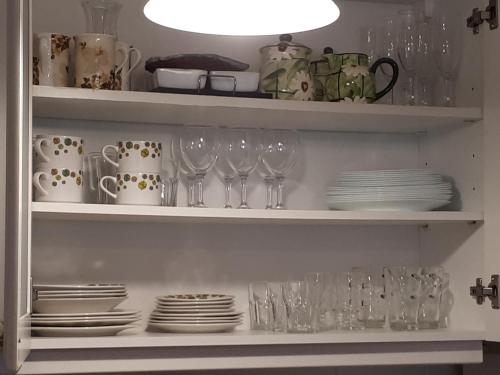 a shelf with glasses and plates and a light at Playa Mansa Parada 8 in Punta del Este