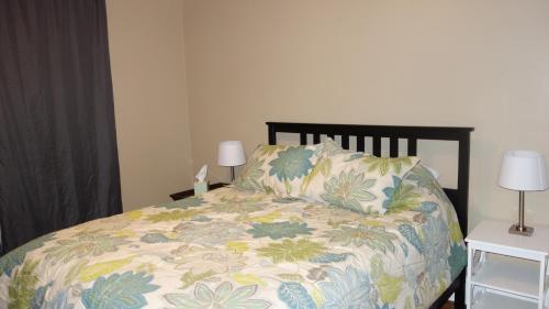 a bedroom with a bed with a floral bedspread and two lamps at The Right Side Duplex in Charlotte