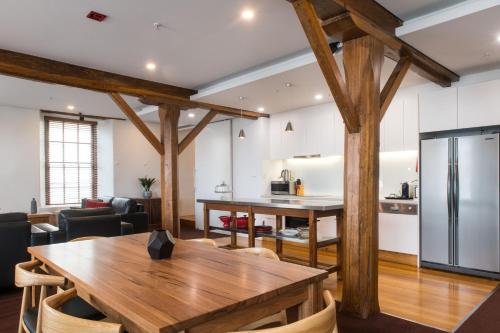 a kitchen and dining room with wooden beams at Sullivans Cove Apartments in Hobart