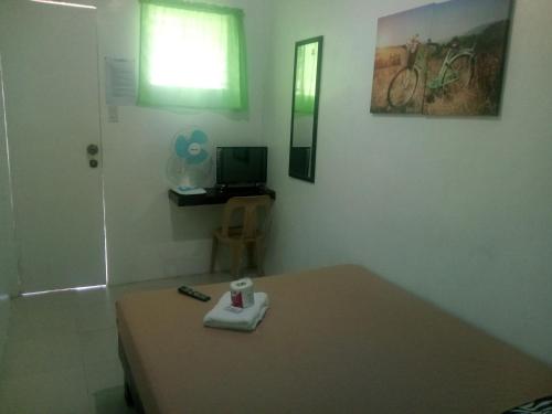 a room with a table with a remote control and a television at Dahilig Resort in Puerto Galera