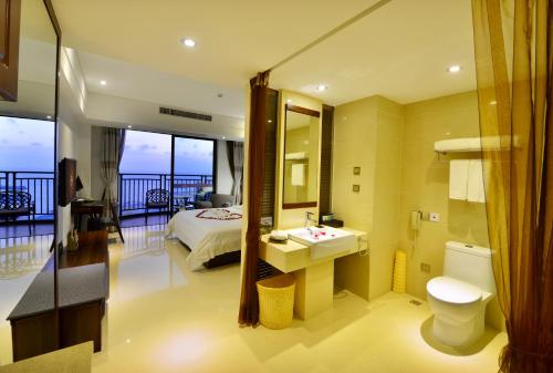 a hotel room with a bathroom with a bed and a sink at Barry Boutique Hotel Sanya in Sanya