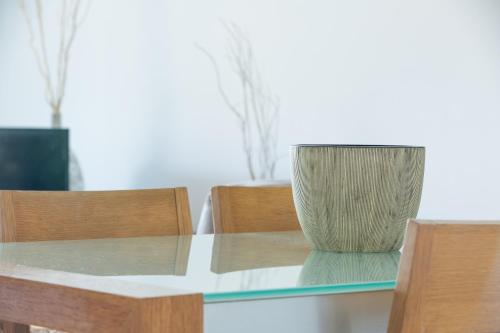 a glass table with a vase on top of it at Azure Sea Whitsunday Resort in Airlie Beach