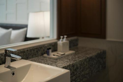 a bathroom with a sink and a mirror at Casa Vimaya Riverside in Bangkok
