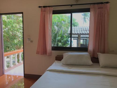 a bedroom with a bed and a large window at Paradise Lamai Bungalow in Lamai