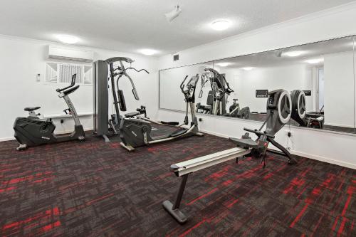 a gym with three tread machines and a mirror at Azure Sea Whitsunday Resort in Airlie Beach