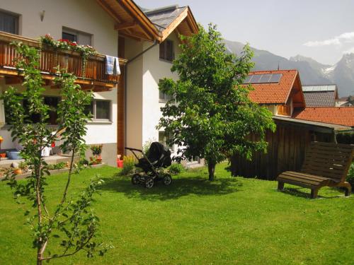 a stroller sitting in a yard next to a bench at Ferienhaus Gundi in Pettneu am Arlberg