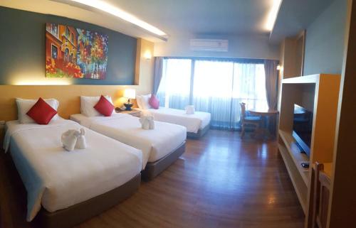 a hotel room with two beds and a television at Le Naview @Prasingh in Chiang Mai
