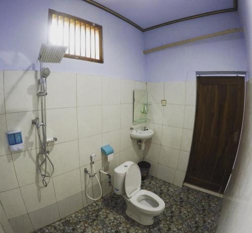 a bathroom with a toilet and a sink at Danke Lodge in Labuan Bajo