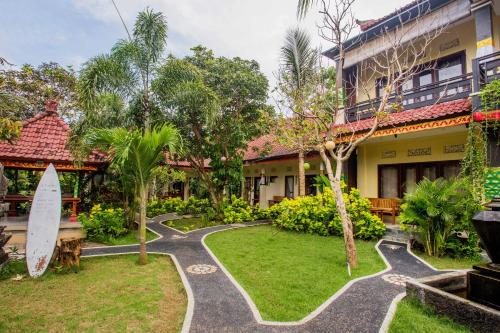una casa con una tabla de surf en el patio en Taos House Lembongan By DeWizZ Management, en Nusa Lembongan