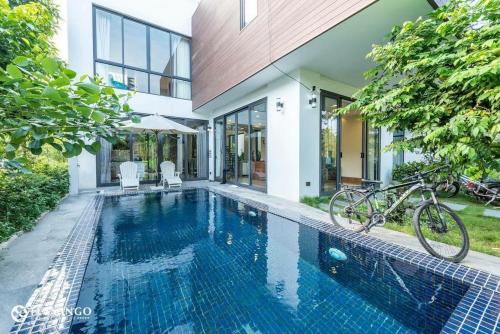 a bicycle parked next to a house with a swimming pool at Flamingo Dailai - HQ villa in Ngọc Quang