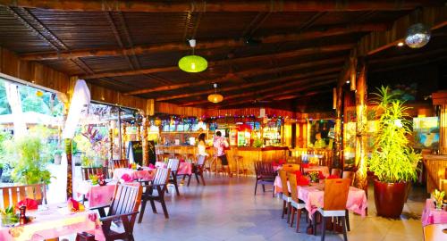 a restaurant with tables and chairs and a bar at Le Vasa Resort in Fuailalo