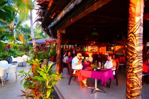 a group of people sitting at a table in a restaurant at Le Vasa Resort in Fuailalo