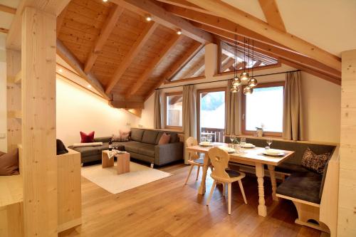 a dining room and living room with a wooden ceiling at Sule Hof Agriturismo in Ortisei