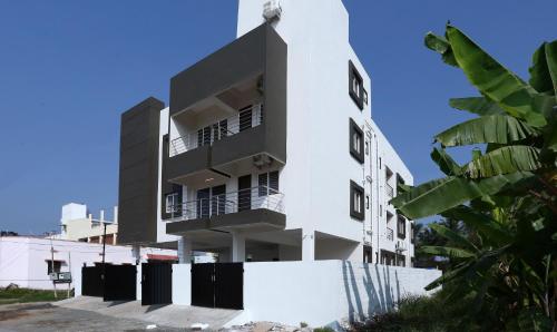a white building with a black at Treebo Hi Line Apartments Kalapatti in Coimbatore