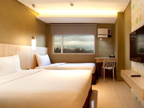ein Hotelzimmer mit 2 Betten und einem Fenster in der Unterkunft Hotel 101 - Manila in Manila
