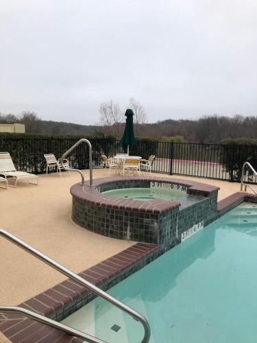 a swimming pool with a patio and a table and chairs at Americas Best Value Inn - Gun Barrel City in Gun Barrel City