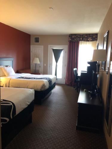 a hotel room with two beds and a window at Americas Best Value Inn - Gun Barrel City in Gun Barrel City