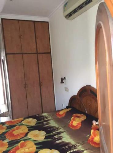 ルディヤーナーにあるSidhu Houseのベッドルーム1室(花の毛布付きのベッド1台付)