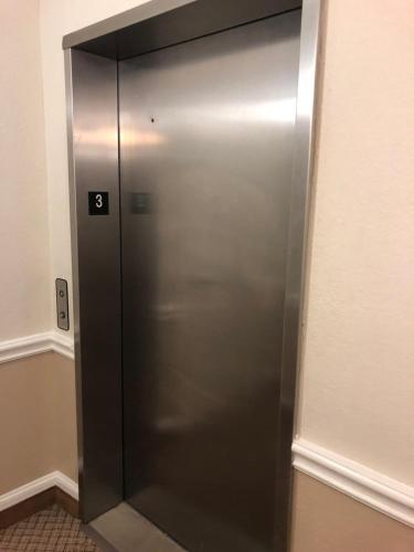 a elevator with a metal door in a room at Americas Best Value Inn - Gun Barrel City in Gun Barrel City