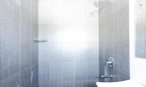 a bathroom with a shower with a toilet in it at Treebo Hi Line Apartments Kalapatti in Coimbatore