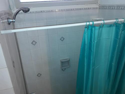 y baño con ducha con cortina azul. en ciudad arcobaleno, en Punta del Este