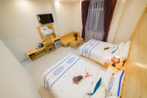una camera d'albergo con due letti e una televisione di Starhill Hotel a Da Lat