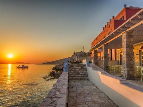 a sunset over a body of water with buildings at Aretanassa Hotel in Halki