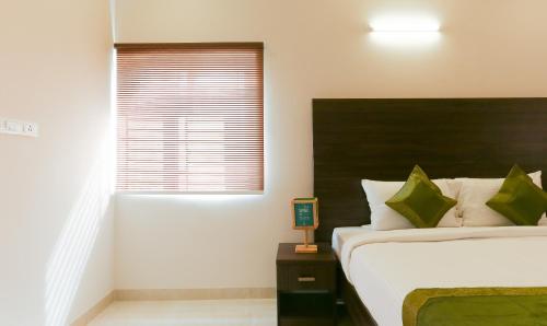 a bedroom with a large bed and a window at Treebo Hi Line Apartments Kalapatti in Coimbatore