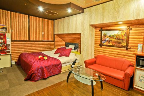 1 dormitorio con 1 cama, 1 silla y 1 mesa de cristal en Hotel Omochabako (Love Hotel), en Kurume