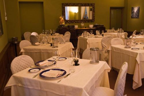 a dining room with white tables and chairs and a mirror at Hotel Villa La Principessa in Lucca