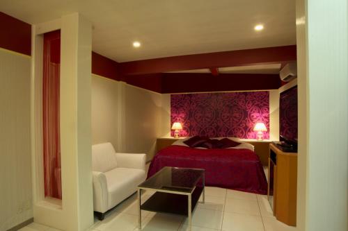 a bedroom with a bed and a couch and a chair at Hotel Coco-Palm (Love Hotel) in Tosu