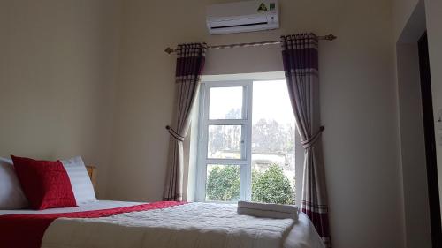 a bedroom with a bed and a window at Tam Coc Mountain Lake Homestay in Ninh Binh