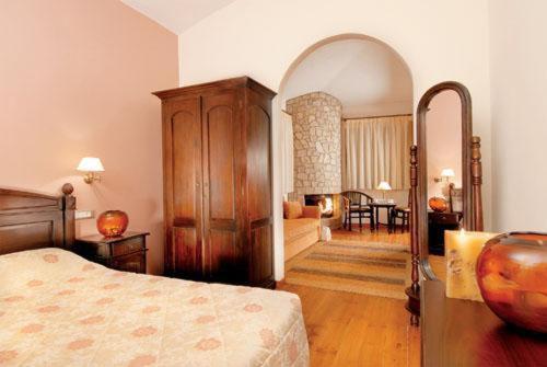 a bedroom with a bed and a living room at Vytina Mountain View Hotel in Vytina