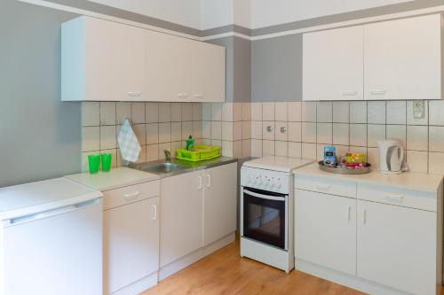 a white kitchen with white cabinets and a sink at Apartment Wideystrasse in Witten