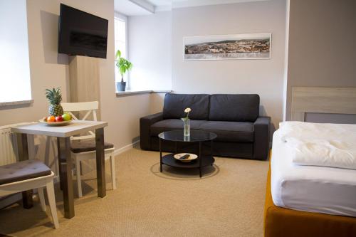 ゲーラにある1880 Lofthaus & Apartmenthausのベッド、ソファ、テーブルが備わる客室です。