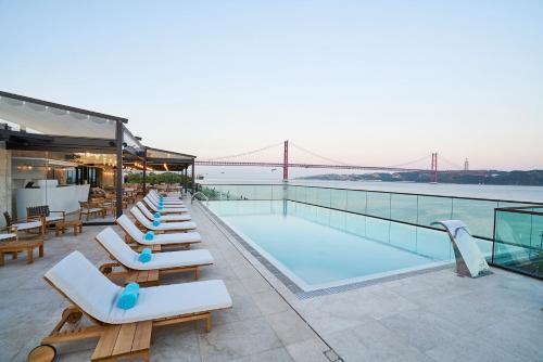 a row of lounge chairs next to a swimming pool at Belem Aloja in Lisbon