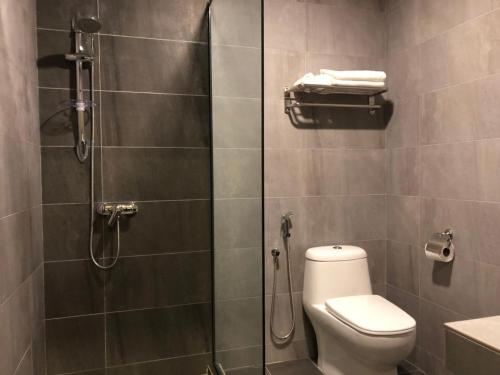 a bathroom with a toilet and a glass shower at K Boutique Hotel in Teluk Intan