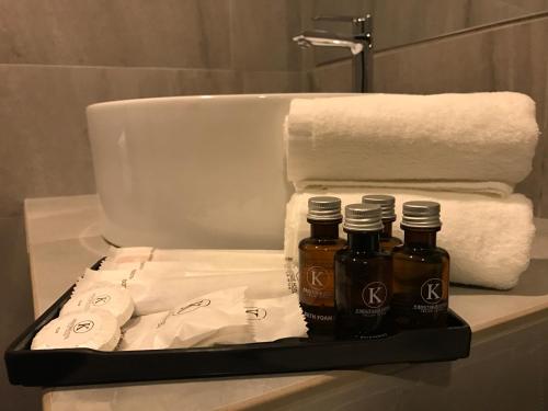 a tray with two bottles of essential oils and towels at K Boutique Hotel in Teluk Intan