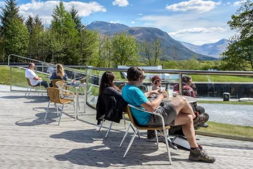 
people sitting around a picnic table at Moorings Hotel in Fort William
