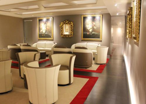 a waiting room with white chairs and paintings on the walls at Harry's Bar Trevi Hotel & Restaurant in Rome