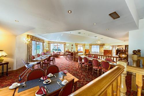 
a dining room filled with tables and chairs at Moorings Hotel in Fort William
