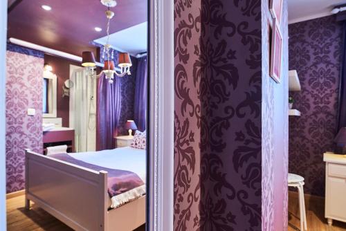 a bedroom with purple walls and a bed and a mirror at Full House Hotel in Kortrijk
