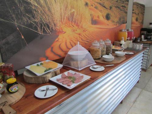 un buffet di carne e altri prodotti alimentari su un bancone di Kalahari Game Lodge a Koës